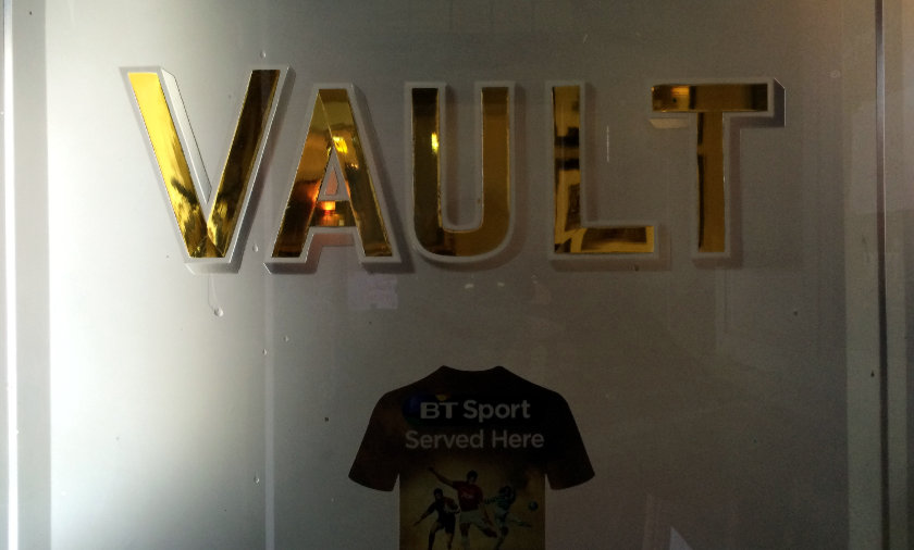 Sign on a frosted glass pub door: VAULT.