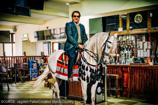 A man astride a horse in the public bar of a pub.