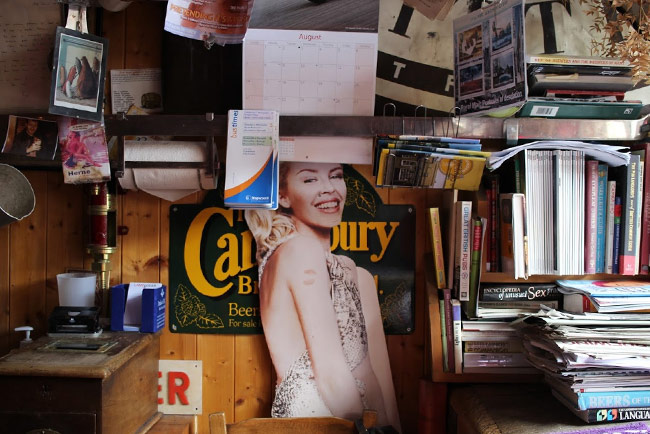 A wall at the Butcher's Arms in Herne with books, posters, leaflets, and a cut out of Kylie Minogue.