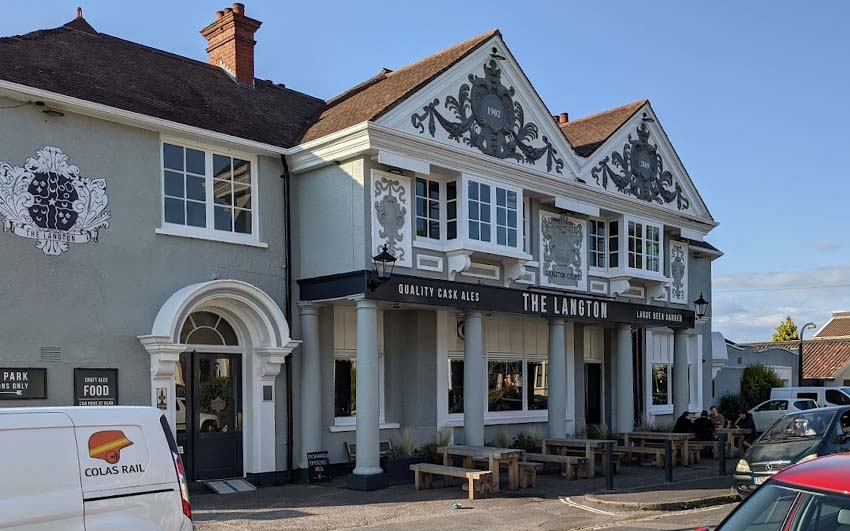 The exterior of a grand Edwardian pub with ornate gables, painted grey.