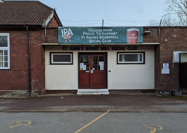 The front of the social club with a Greene King ale banner.