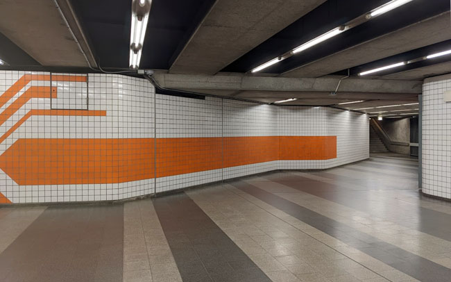 An underground station in Nuremberg with orange and white tiles.