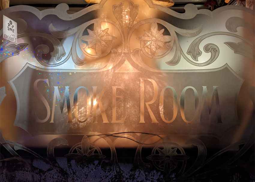 An etched window with the words SMOKE ROOM in Edwardian lettering.