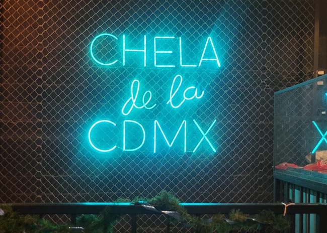 A neon sign in a Mexico City bar: "Chela de la MX".