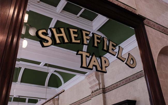An engraved mirror with the name Sheffield Tap.
