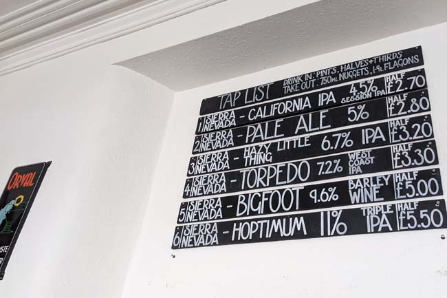 The tap list in chalk on the wall, including Sierra Nevada Pale Ale at £2.80 a half, Torpedo IPA at £3.30 a half and Bigfoot Barley Wine at £5 a half.