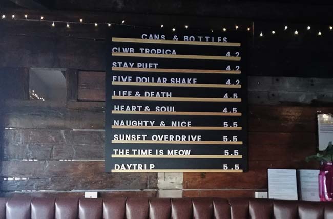 The beer menu at a craft beer bar with various beers from Tiny Rebel and others.