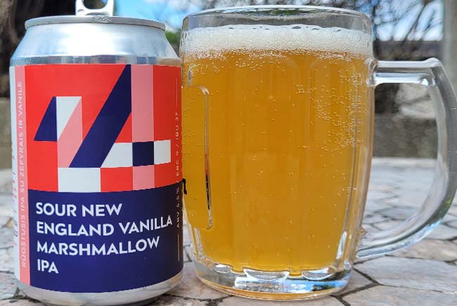 A glass of hazy golden beer next to a colourful can labelled "Sour New England Vanilla Marshmallow IPA".