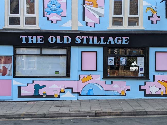 The front of The Old Stillage with graffiti style mural in pink and blue.
