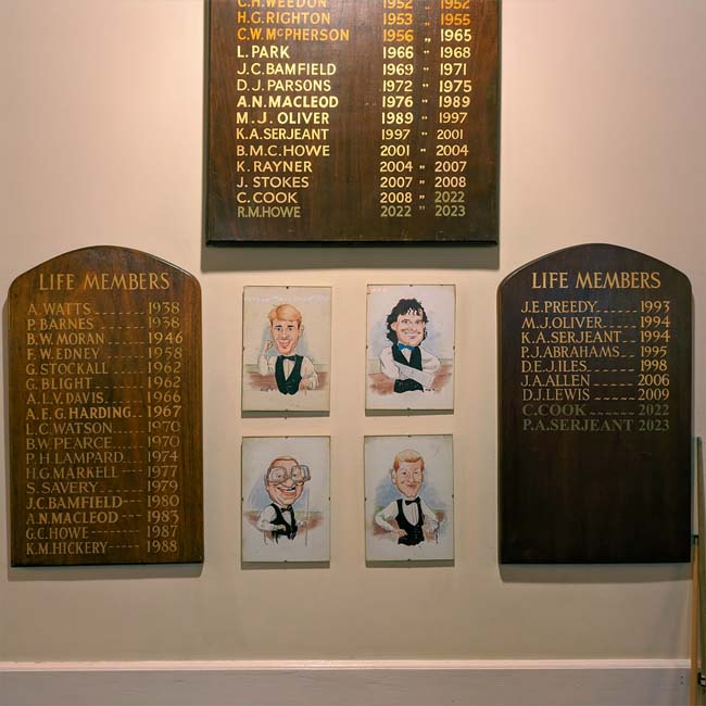 Wooden boards listing life members of the Somerville Club next to a set of caricatures of famous snooker players, including Jimmy White and Steve Davis.