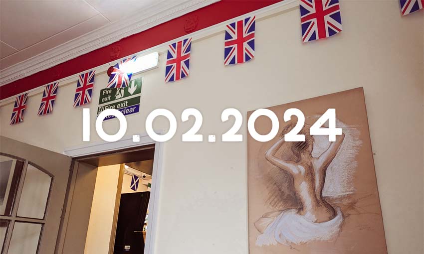 A room in a pub with union jack bunting and a charcoal sketch of a semi-nude woman with her naked back to the artist.