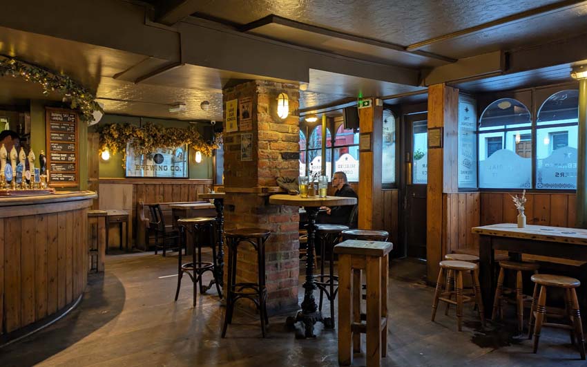 The interior of The Evening Star with wooden floorboards, wooden furniture, and a nice vibe.