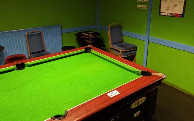 A pub pool table with bright green baize.